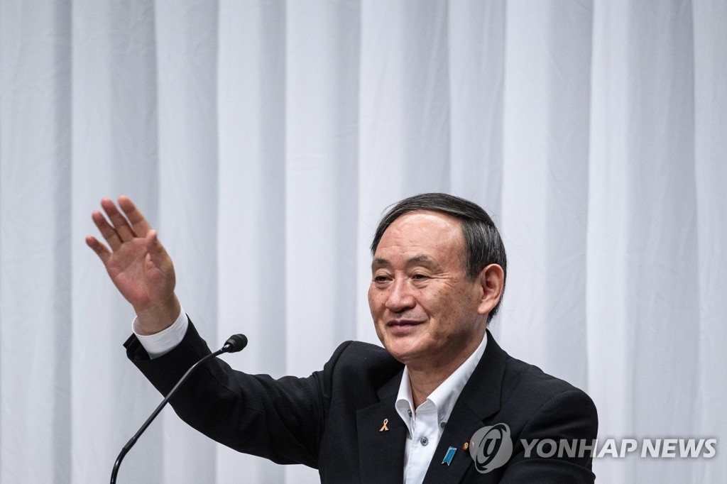 토론회에서 손 흔드는 스가 일본 관방장관
