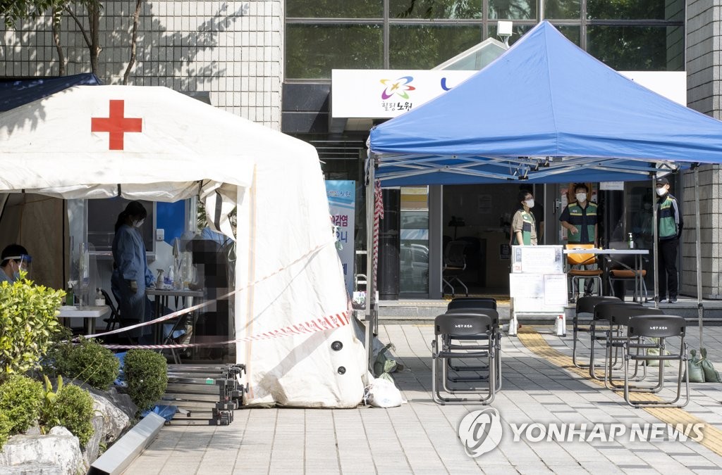 A visitor consults with a medical worker at a COVID-19 testing station at a community health center in Seoul on Sept. 14, 2020, when the number of new cases stood at 109, including 11 entrants from abroad, marking the 12th consecutive day the figure had stayed in the 100 level. (Yonhap)