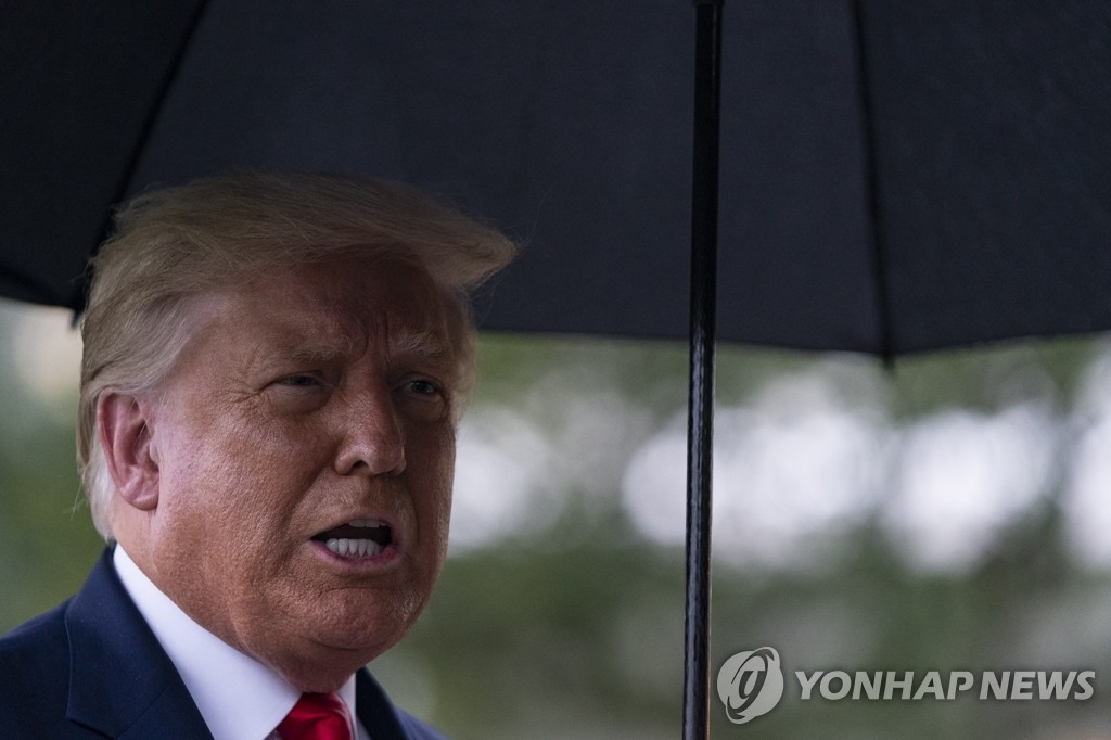 우산 들고 취재진에게 발언하는 트럼프