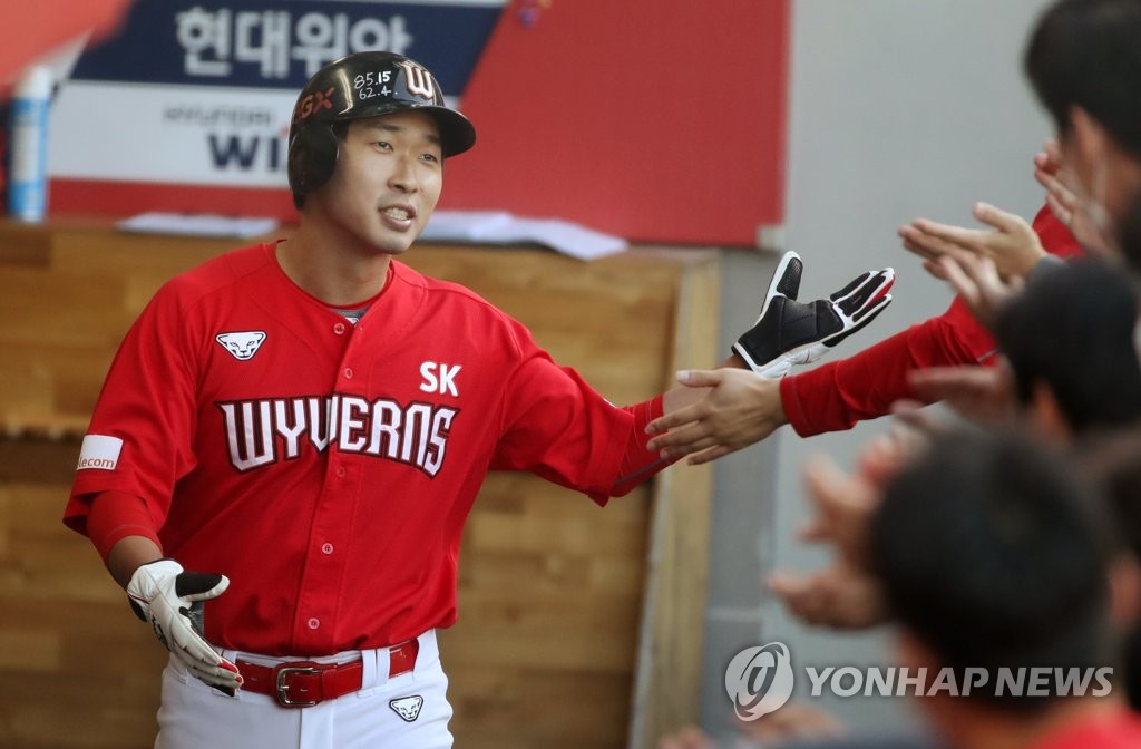 In this file photo from Oct. 11, 2020, Ko Jong-wook of the SK Wyverns is greeted by his teammates in the dugout after scoring a run against the Kia Tigers in a Korea Baseball Organization regular season game at Gwangju-Kia Champions Field in Gwangju, 330 kilometers south of Seoul. (Yonhap)