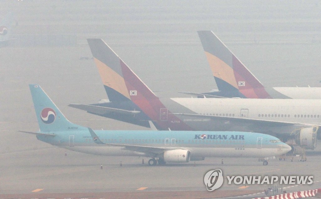 霧の仁川空港に並ぶ大韓航空機とアシアナ航空機＝１３日、仁川（聯合ニュース）