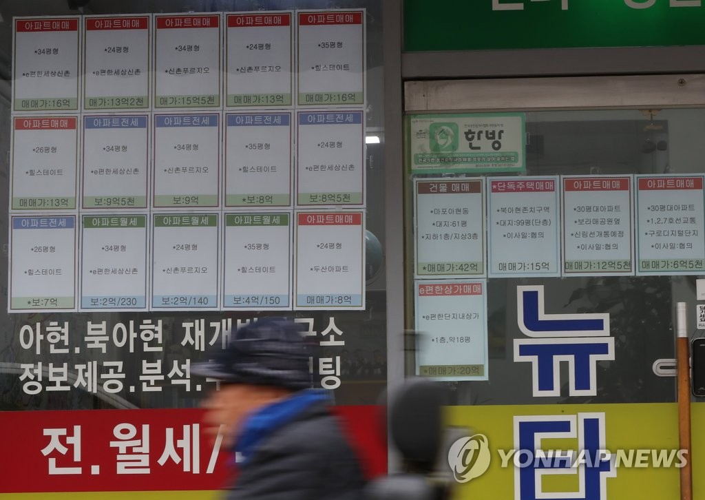 A pedestrian passes by a real estate brokerage office in western Seoul on Nov. 2020. (Yonhap)