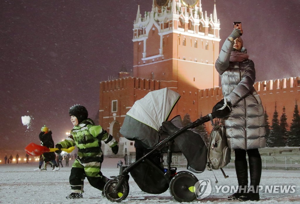 눈 내린 모스크바 붉은광장 산책하는 러시아인 모자