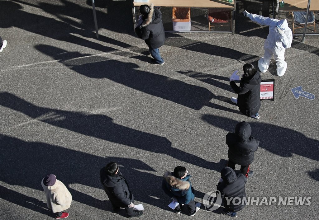 Citizens wait in line to receive COVID-19 tests at a makeshift clinic in western Seoul on Dec. 15, 2020. (Yonhap)