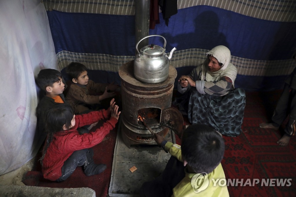 임시 피난처 난로 곁에서 몸 녹이는 아프간 어린이들