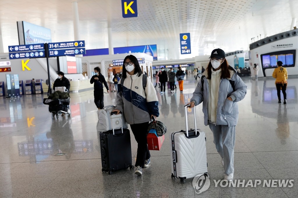 신종 코로나바이러스 감염증(코로나19) 발원지로 지목된 중국 후베이성 우한의 국제공항에서 지난 2일 여행객들이 가방을 끌고 지나고 있다. [로이터=연합뉴스 자료사진]