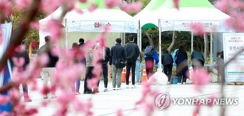 People line up to be tested for COVID-19 at a temporary facility center in Daegu, 238 kilometers southeast of Seoul, on March 7, 2021. (Yonhap)