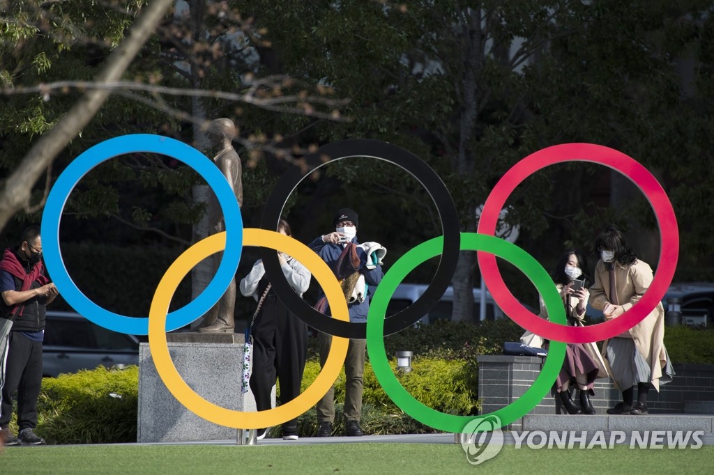 일본 도쿄도(東京都) 소재 도쿄올림픽 박물관 앞에서 시민들이 오륜 조형물을 배경으로 사진을 찍고 있다. [AP=연합뉴스 자료사진]