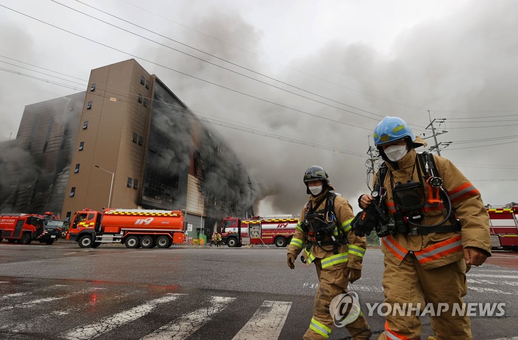 Firefighters are seen at the site of a fire at a Coupang distribution center in Icheon, some 80 kilometers south of Seoul, on June 18, 2021. (Yonhap)