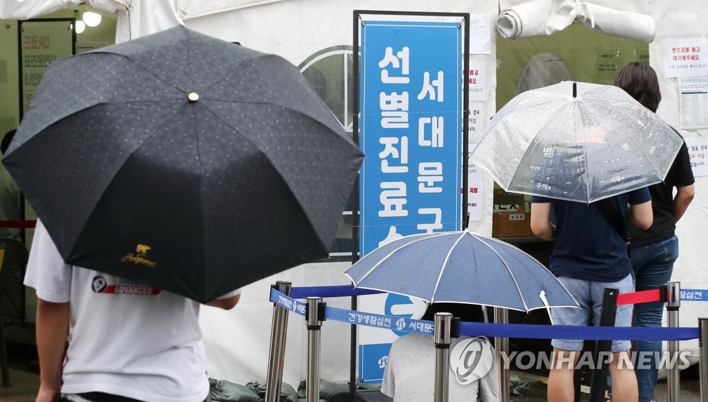 우산 쓰고 코로나 검사 기다리는 시민들
