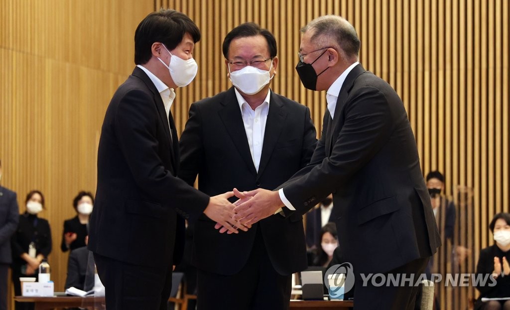 Labor Minister An Kyung-duk (L) shakes hands with Hyundai Motor Group Chairman Euisun Chung as Prime Minister Kim Boo-kyum (C) watches them during the "Youth Hope ON" event at Hyundai Motor Studio in Goyang, northwest of Seoul, on Nov. 22, 2021. (Yonhap)