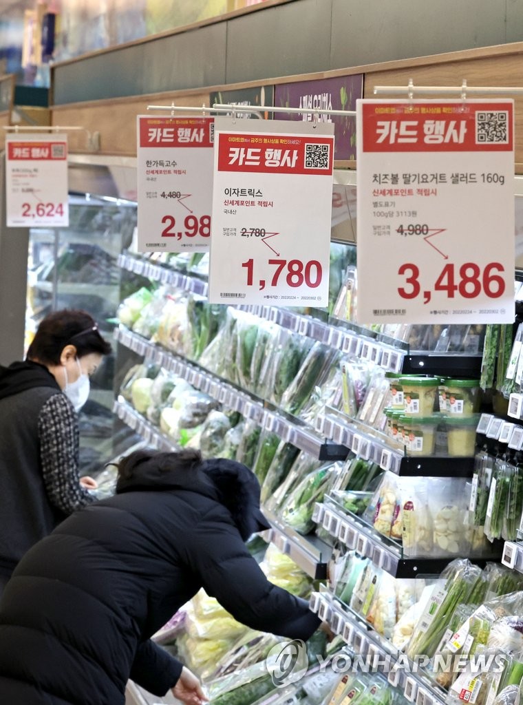 Shoppers look at produce at a supermarket in Seoul, in the Feb. 24, 2022, file photo. The Bank of Korea revised its outlook for inflation this year sharply upward to 3.1 percent from 2 percent predicted in November amid surging energy costs, marking the first time that the inflation outlook has been raised above 3 percent since April 2012. (Yonhap)
