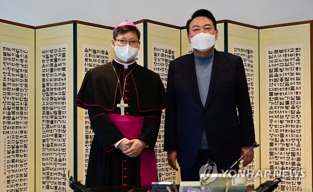 President-elect Yoon Suk-yeol (R) poses for a photo with Peter Chung Soon-taick, the archbishop of Seoul, at Myeongdong Cathedral in central Seoul on March 30, 2022. (Pool photo) (Yonhap)