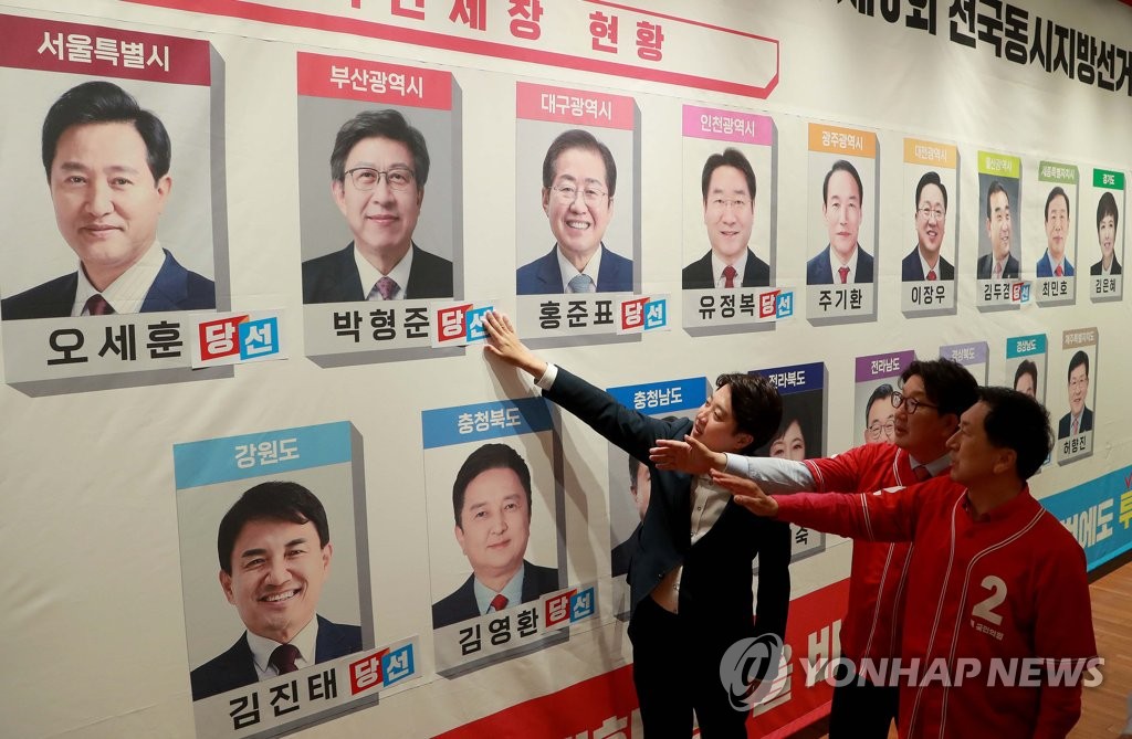 당선 유력 단체장 후보 사진에 스티커 붙이는 국민의힘 지도부