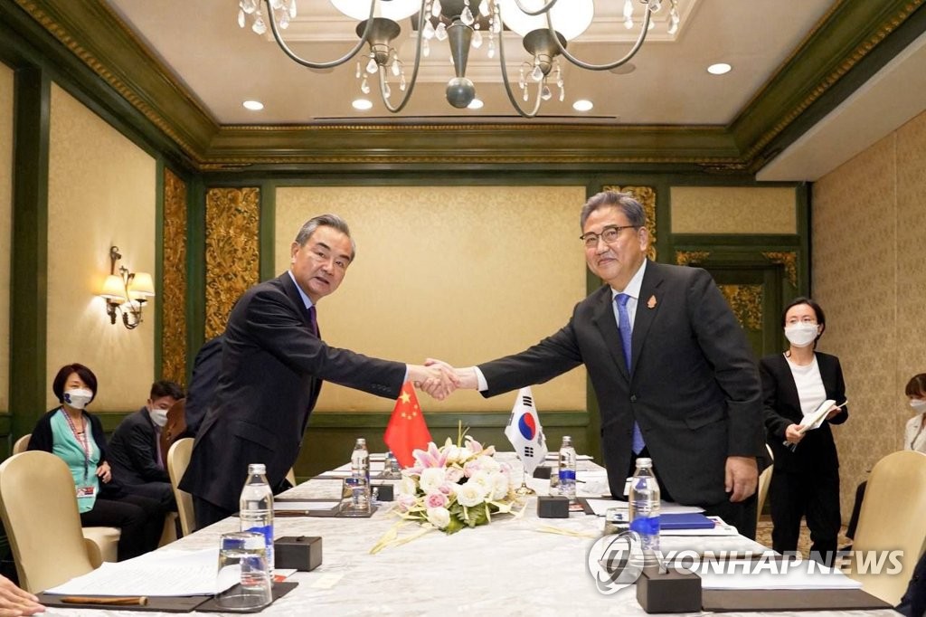 South Korean Foreign Minister Park Jin (R) shakes hands with his Chinese counterpart Wang Yi during their meeting in Bali, Indonesia, on July 7, 2022, on the sidelines of the G-20 foreign ministerial meeting, in this photo provided by Park's office. (PHOTO NOT FOR SALE) (Yonhap)