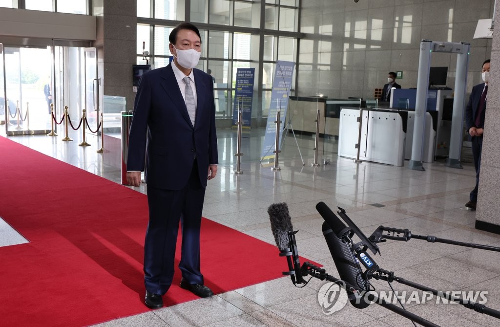 President Yoon Suk-yeol takes reporters' questions as he arrives at the presidential office in Seoul on July 26, 2022. (Yonhap)