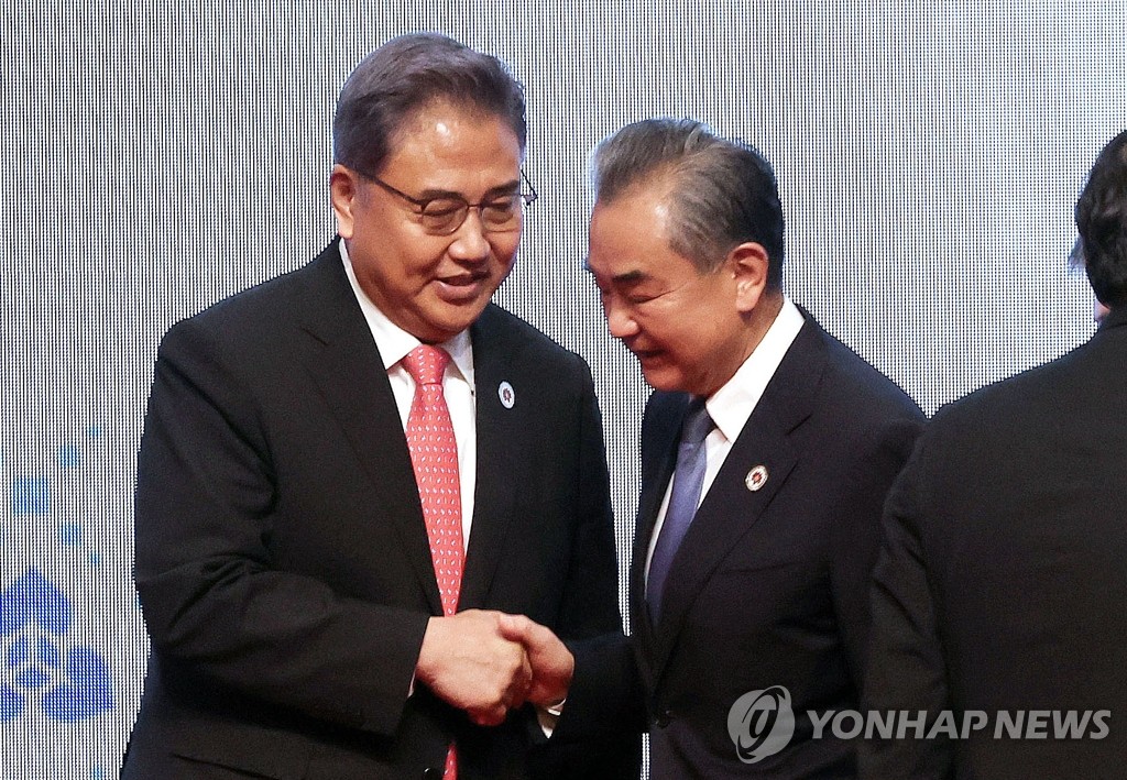 South Korean Foreign Minister Park Jin (L) and his Chinese counterpart, Wang Yi, shakes hands during their ASEAN Plus Three Meeting held in Phnom Penh, Cambodia, on Aug. 4, 2022. (Yonhap) 