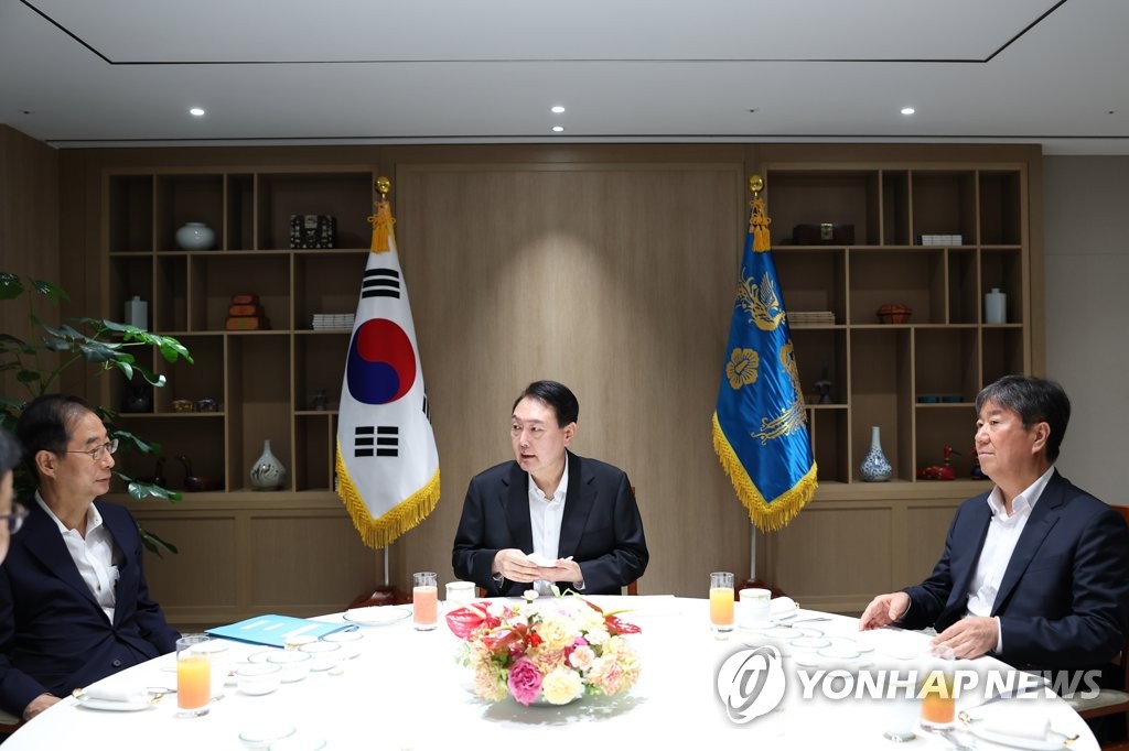 President Yoon Suk-yeol (C) talks with Prime Minister Han Duck-soo (L) during their weekly meeting at the presidential office in Seoul on Aug. 8, 2022, in this photo provided by the office. At right is Presidential Chief of Staff Kim Dae-ki. (PHOTO NOT FOR SALE) (Yonhap)