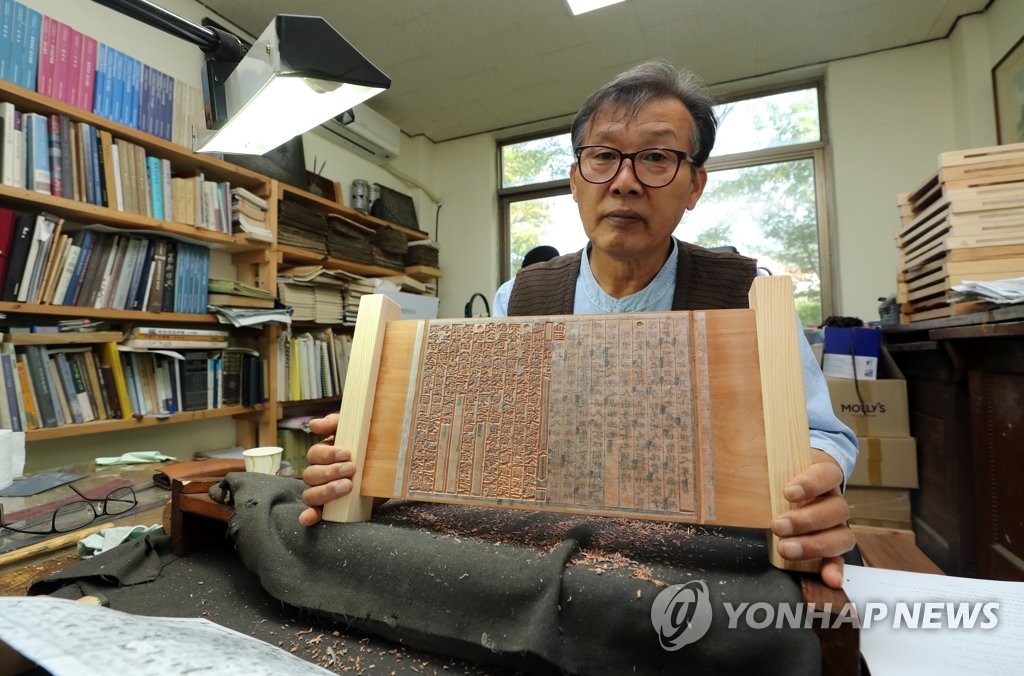활자 새겨 넣은 목판 보여주는 박영덕 장인