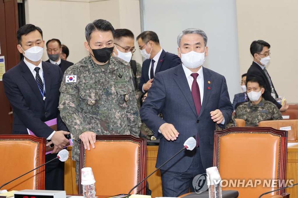 El ministro de Defensa surcoreano, Lee Jong-sup (dcha.), y el jefe de Estado Mayor Conjunto, el general Kim Seung-kyum (segundo por la izda.), toman asiento, el 26 de enero de 2023, en la Asamblea Nacional, en el oeste de Seúl, antes de informar a los legisladores sobre la inspección del Ejército, de varias semanas de duración, de la operación contra los cinco drones norcoreanos que violaron, el 26 de diciembre de 2022, el espacio aéreo surcoreano.