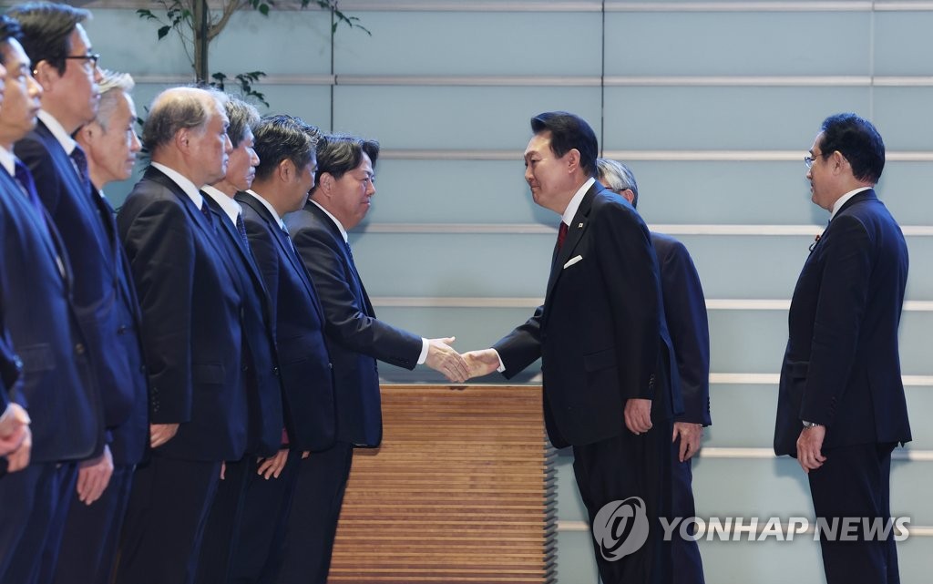 South Korean President Yoon Suk Yeol (2nd from R) shakes hands with Japanese Cabinet members after an honor guard inspection prior to his summit talks with Japanese Prime Minister Fumio Kishida (R) at the latter's residence in Tokyo on March 16, 2023. Earlier in the day, Yoon began a two-day trip to Japan to put strained relations back on track. (Yonhap)
