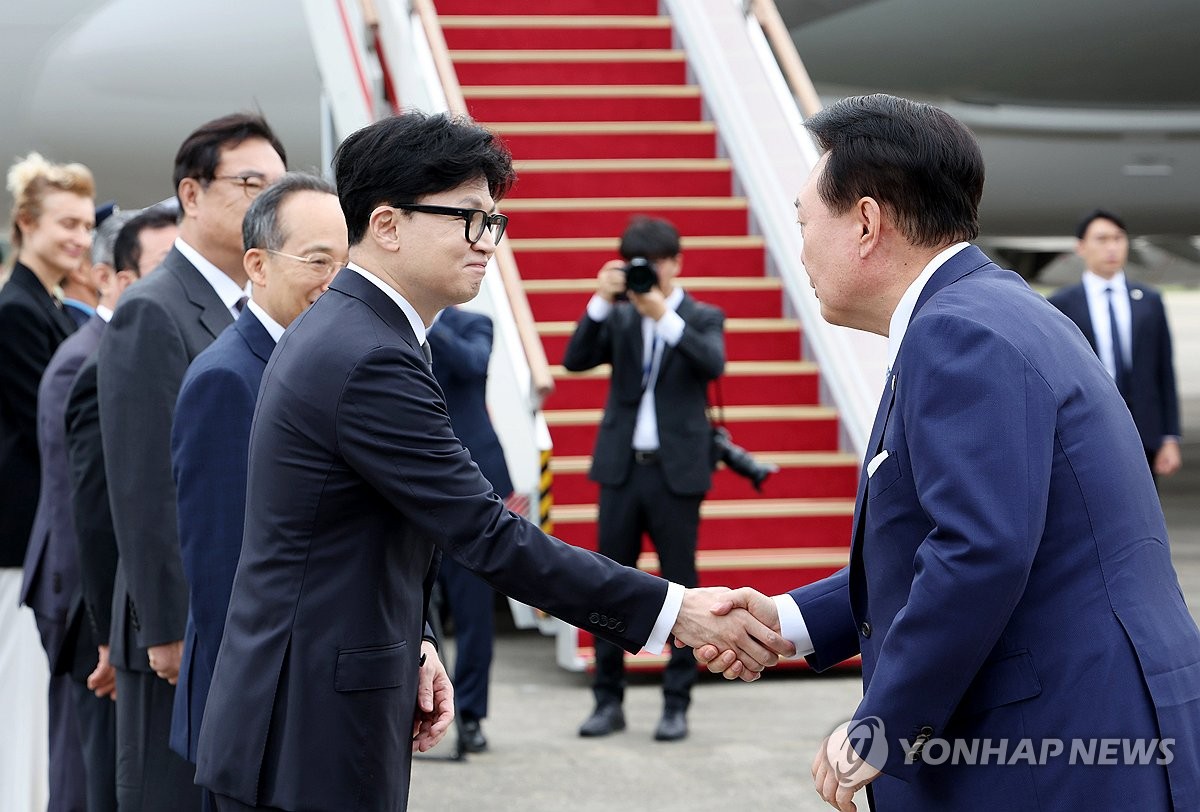 President Yoon Suk Yeol (R) shakes hands with Han Dong-hoon, leader of the ruling People Power Party, on Sept. 19, 2024, as Yoon departs for the Czech Republic at Seoul Air Base in Seongnam. (Yonhap)