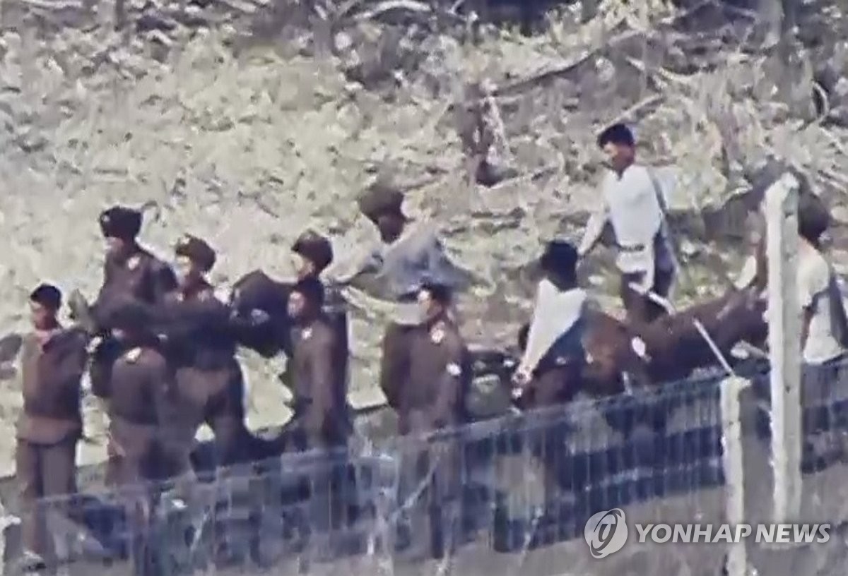 North Korean soldiers hold stretchers that appear to be carrying soldiers wounded or killed due to landmine explosions, while conducting construction activities in the North's eastern front, in this photo provided by South Korea's Joint Chiefs of Staff on March 27, 2025. (PHOTO NOT FOR SALE) (Yonhap)