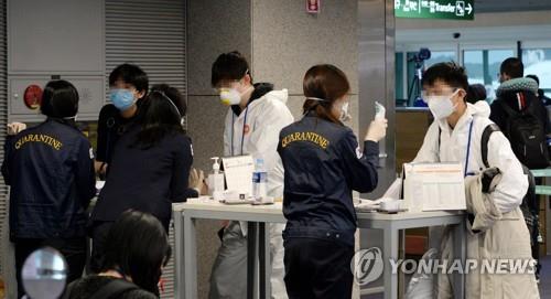 资料图片：3月23日，在仁川国际机场，来自欧洲的旅客回答检疫工作人员的提问。 韩联社