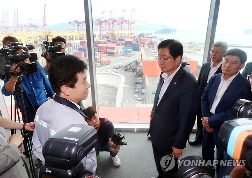 Minister of Oceans and Fisheries Kim Young-suk (3rd from R) listens to an official during his visit to a Hanjin Shipping container terminal in Busan on Sept. 5, 2016. (Yonhap)