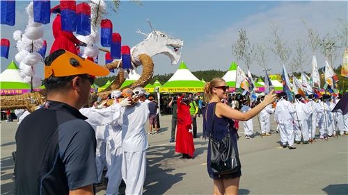 An international visitor takes photos of the Korean performers at the Myeongnyang Festival in Haenam, South Jeolla Province, on Sept. 3, 2016. (Yonhap)