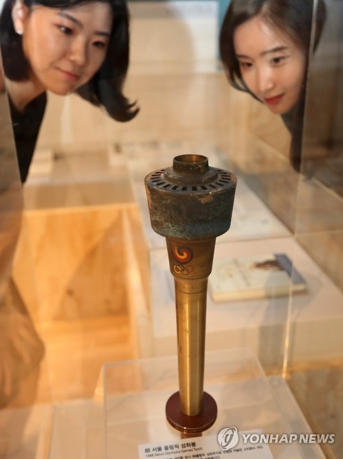 Visitors take a look at a sacred torch used in the 1988 Seoul Olympic Games at the National Museum of Korean Contemporary History on Sept. 12, 2016. (Yonhap)