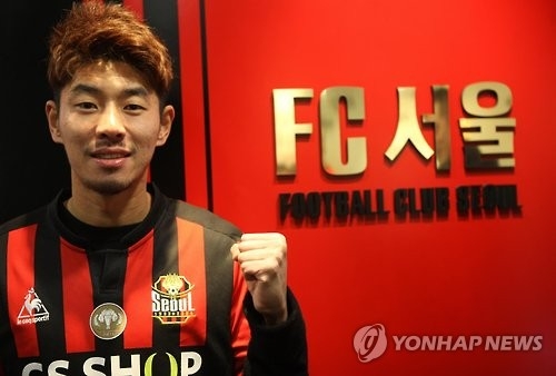 In this photo provided by FC Seoul on Jan. 19, 2017, midfielder Ha Dae-sung poses next to the team's logo after signing with the club. (Yonhap)