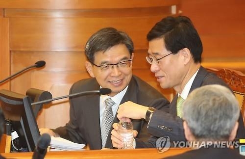 Lee Joong-hwan (L) speaks with a colleague during the 10th hearing of President Park Geun-hye's impeachment trial at the Constitutional Court in Seoul on Feb. 1, 2017. (Yonhap)
