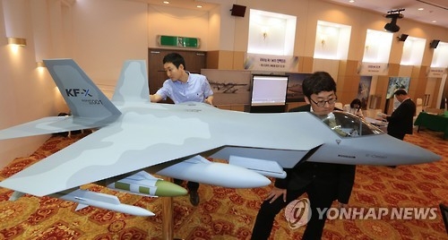 In this photo taken on June 14, 2016, military officials take a look at a KF-X model aircraft displayed during an exhibition held in an Air Force building in Seoul. (Yonhap) 