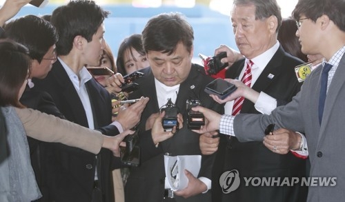 Chung Kwang-yong (C) is surrounded by reporters as he enters the Jongno Police Station in downtown Seoul on April 12, 2017. (Yonhap)