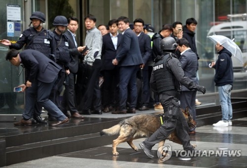Samsung Life Insurance employees look on while police conduct a search of the company building in southern Seoul on April 14, 2017. (Yonhap)