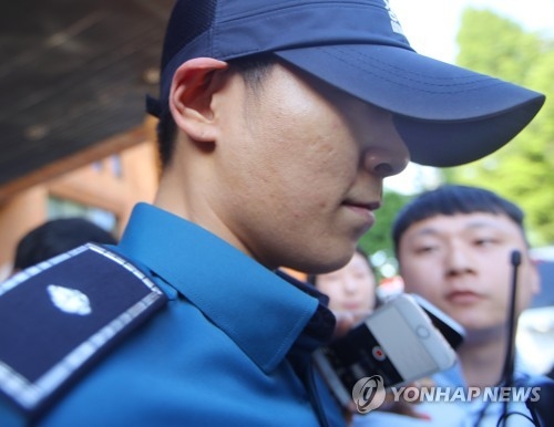 South Korean singer and actor T.O.P. of boy band BIGBANG, who is serving his mandatory military service as a conscripted policeman, leaves his workplace in Seoul surrounded by reporters questioning his marijuana charges on June, 5, 2017. (Yonhap)