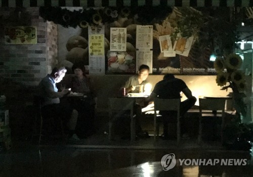 In this photo provided by a reader, diners at a restaurant eat in the dark after a power failure at Techno Mart in southwestern Seoul on June 11, 2017. (Yonhap)