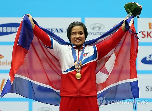 In this file photo taken on Sept. 25, 2014, North Korean weightlifter Kim Un-ju holds up her national flag after winning the gold medal in the women's 75kg class at the Incheon Asian Games in Incheon. (Yonhap)