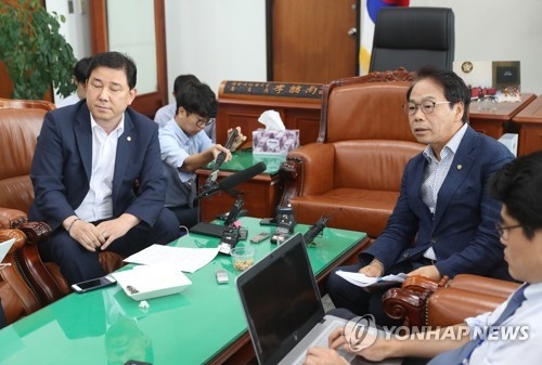 Rep. Kim Byung-kee of the ruling Democratic Party and Yi Wan-young of the Liberty Korea Party brief reporters after a meeting of the parliamentary intelligence committee on July 11, 2017. (Yonhap) 