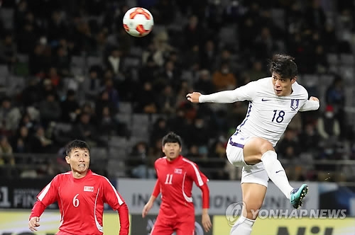 South Korean striker Jin Seong-uk (R) makes a header during the match between South Korea and North Korea at the EAFF E-1 Football Championship at Ajinomoto Stadium in Tokyo on Dec. 12, 2017. (Yonhap)