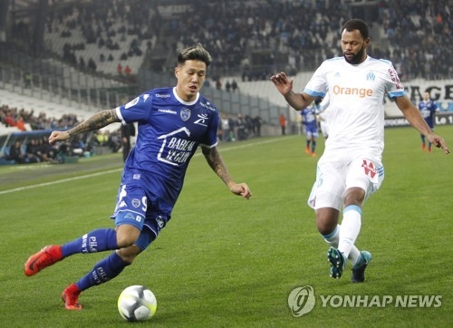 In this photo taken by the Associated Press on Dec. 20, 2017, Troyes forward Suk Hyun-jun (L) dribbles the ball past Marseille's Jorge Pires da Fonseca Rolando during the Ligue 1 match between Marseille and Troyes at the Velodrome stadium in Marseille, southern France. (Yonhap) 