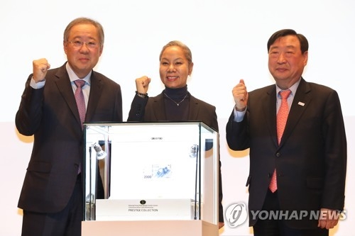 Poongsan Group Chairman Ryu Jin, singer Insooni and POCOG President Lee Hee-beom (from L to R) pose for photos behind a new deluxe coin set commemorating the 2018 PyeongChang Winer Olympics on Jan. 10, 2018 at Poongsan's headquarters in central Seoul. The set is priced at 11 million won and will go on preorder starting Jan. 15, 2018. (Yonhap)