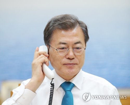 President Moon Jae-in speaks by telephone with Chinese President Xi Jinping at his office Cheong Wa Dae in Seoul on Jan. 11, 2018, in this photo provided by the presidential office. (Yonhap)