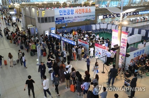 This photo taken June 8, 2018, shows South Koreans lining up to cast ballots in early voting for the June 13 local elections and parliamentary by-elections at Incheon International Airport before departure. (Yonhap)