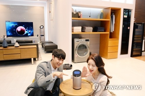 Models pose for a photo with LG Electronics Inc.'s products in this photo released by the company on April 25, 2018. (Yonhap)