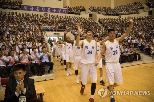 This pool photo taken July 4, 2018, shows South Korean and North Korean men's basketball players entering the court at Ryugyong Chung Ju-yung Gymnasium in Pyongyang for a friendly match. (Yonhap) 