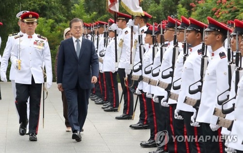 South Korean President Moon Jae-in (2nd from L) inspects Singapore's honor guard during an official welcoming ceremony to mark his state visit to Singapore on July 12, 2018. (Yonhap)