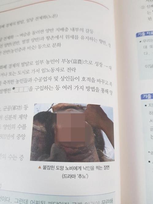 This photo captured from DCInside, an Internet chatting website, shows a controversial photo of former President Roh Moo-hyun in a book published by Kyohaksa. (Yonhap)