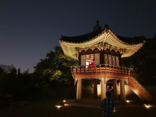 A musician plays a "daegeum," a Korean bamboo flute, in a pavilion inside the Changdeok Palace in Seoul on May 16, 2019. (Yonhap)